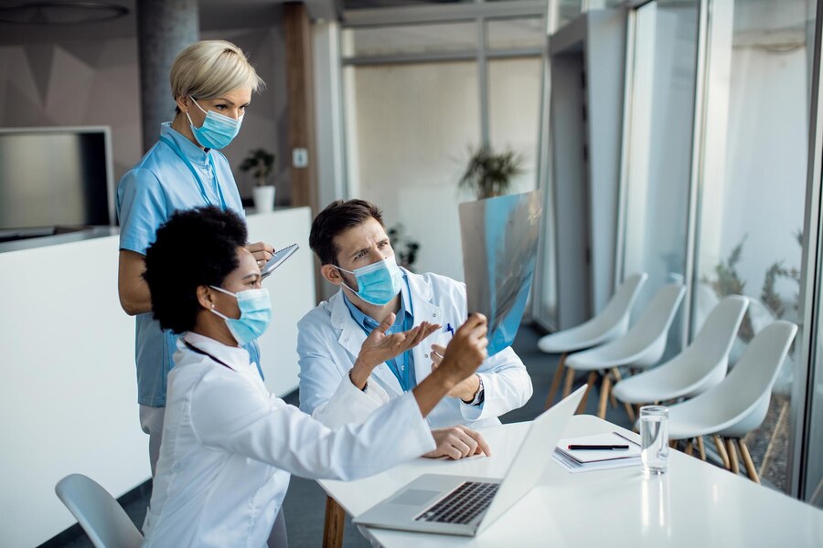 groupe-medecins-cooperant-tout-examinant-radiographie-patient-hopital_637285-11164